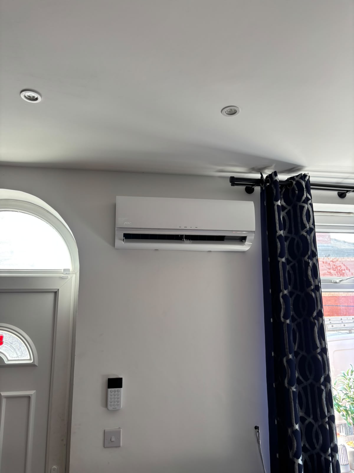 iPAC wall-mounted air conditioning unit installed high on a lounge wall