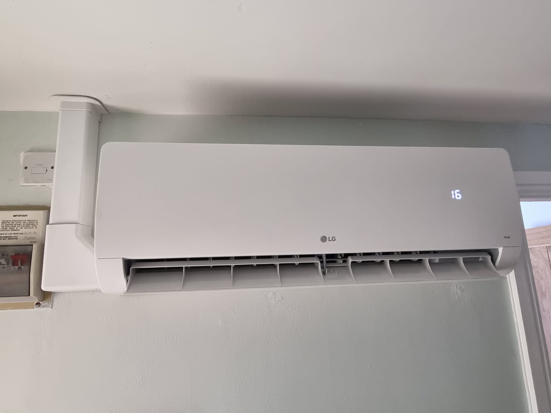 LG wall-mounted air conditioning unit with white trunking running neatly along the ceiling